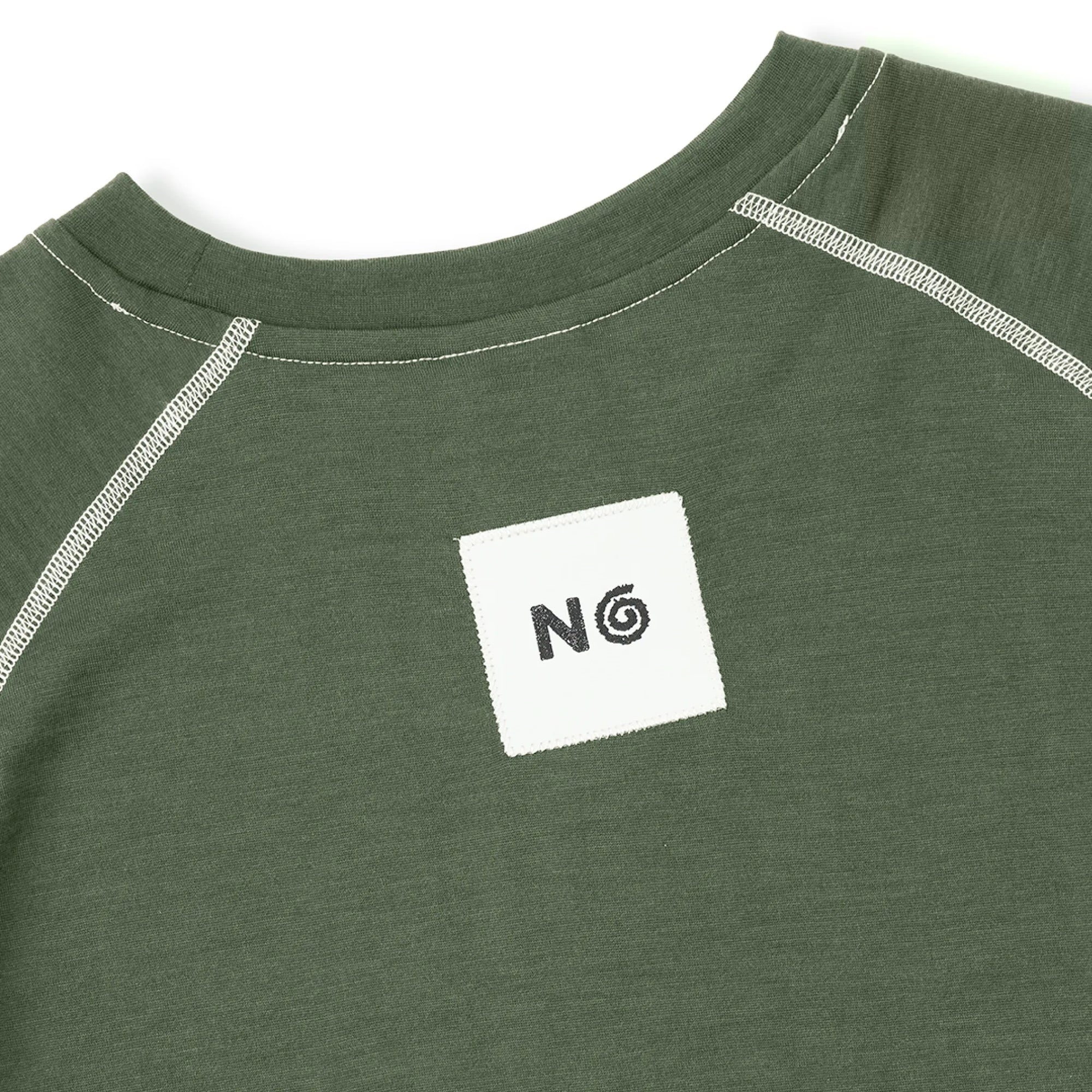 Green shirt with a white square patch featuring a logo on a white background