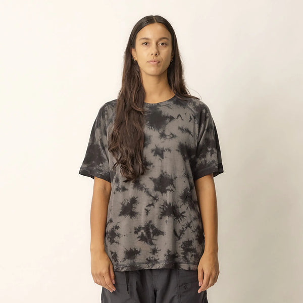 Person wearing a black tie-dye t-shirt against a plain background