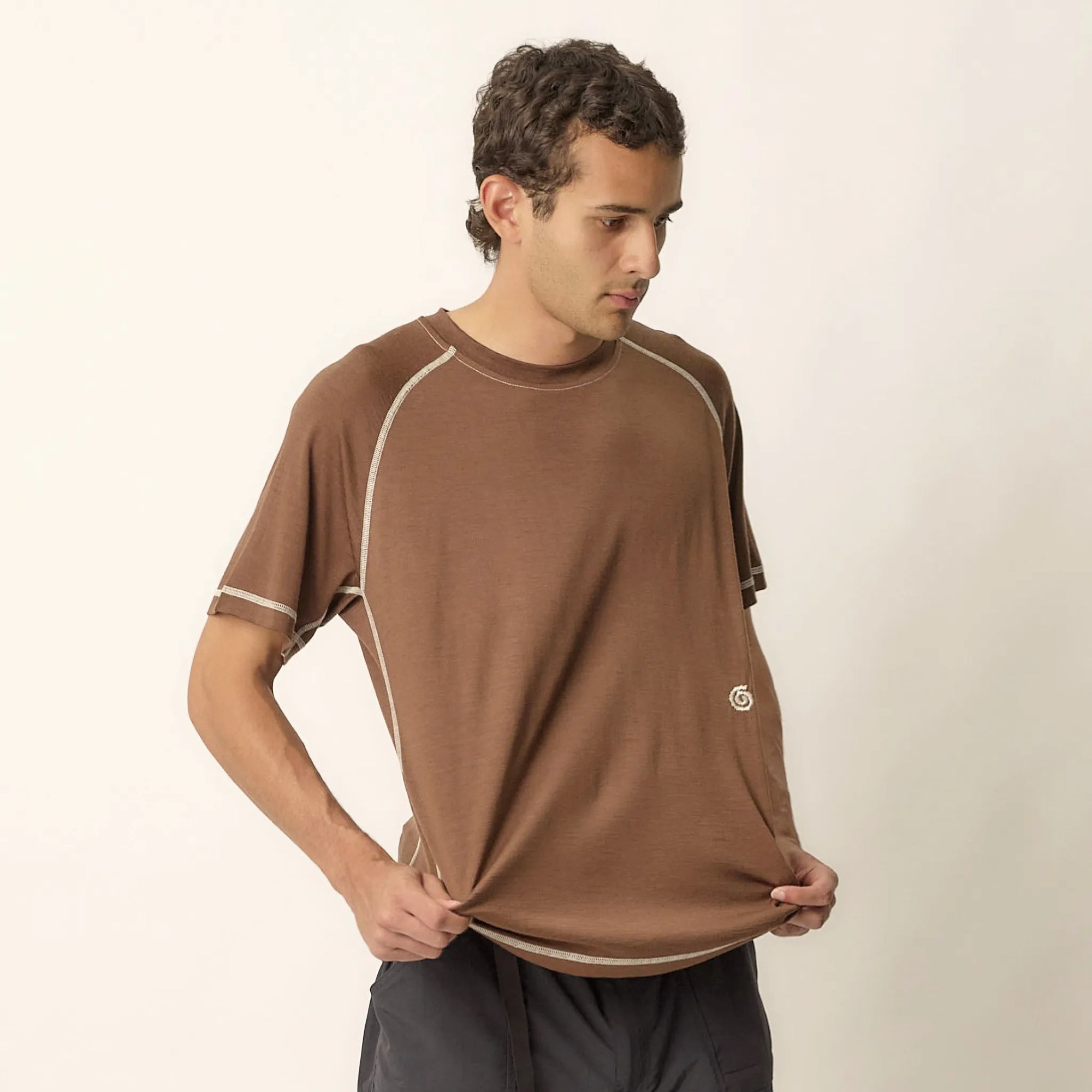 Man wearing a brown athletic shirt on a plain background