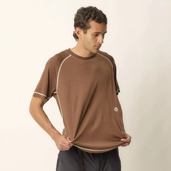 Man wearing a brown athletic shirt on a plain background
