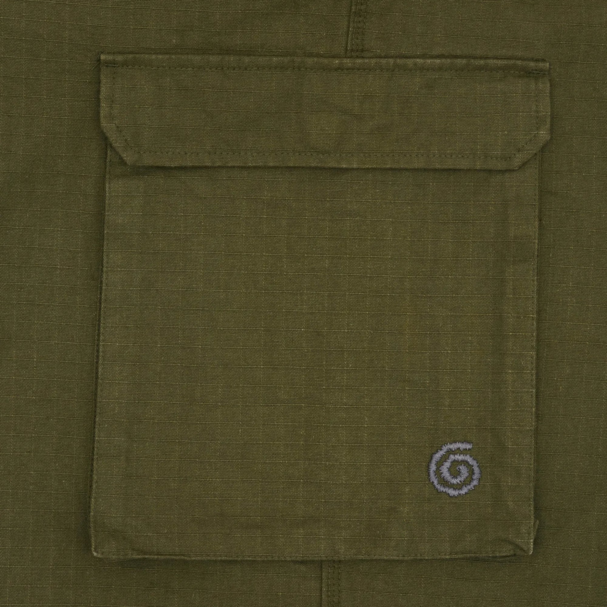 Close-up of a green pocket with a small spiral logo on a green background