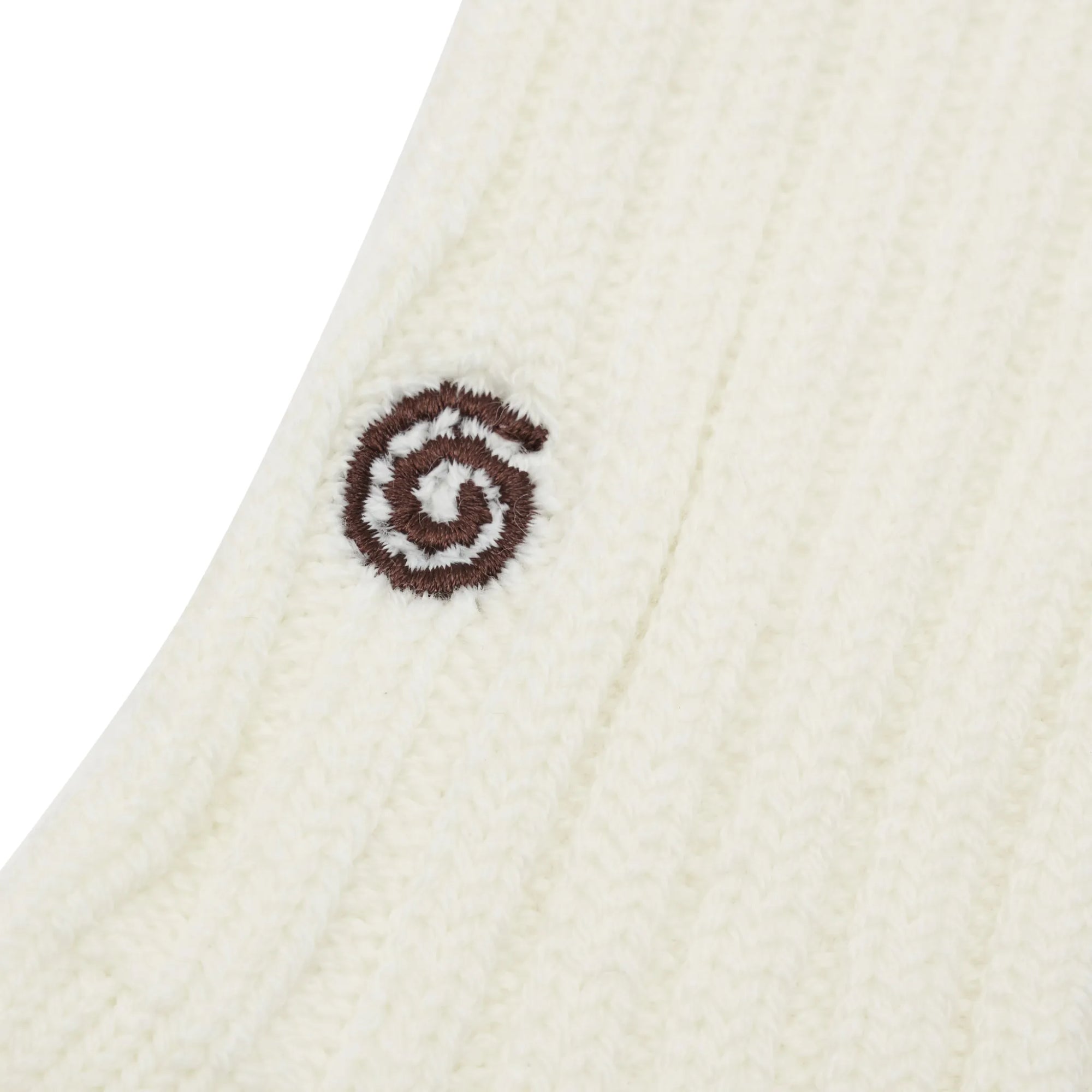 Close-up of a white knitted fabric with a brown logo on a white background